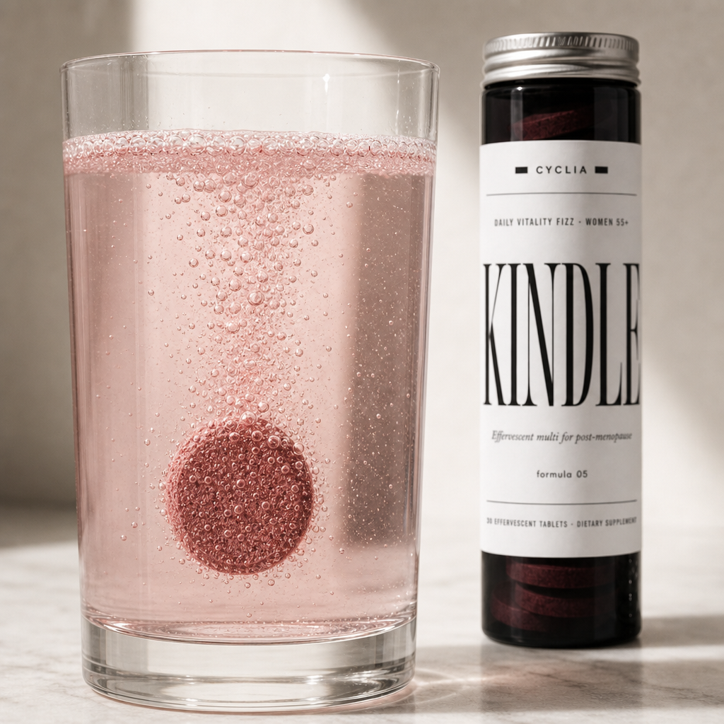 A Kindle effervescent tablet fizzing in a tall glass of water on a bright kitchen counter