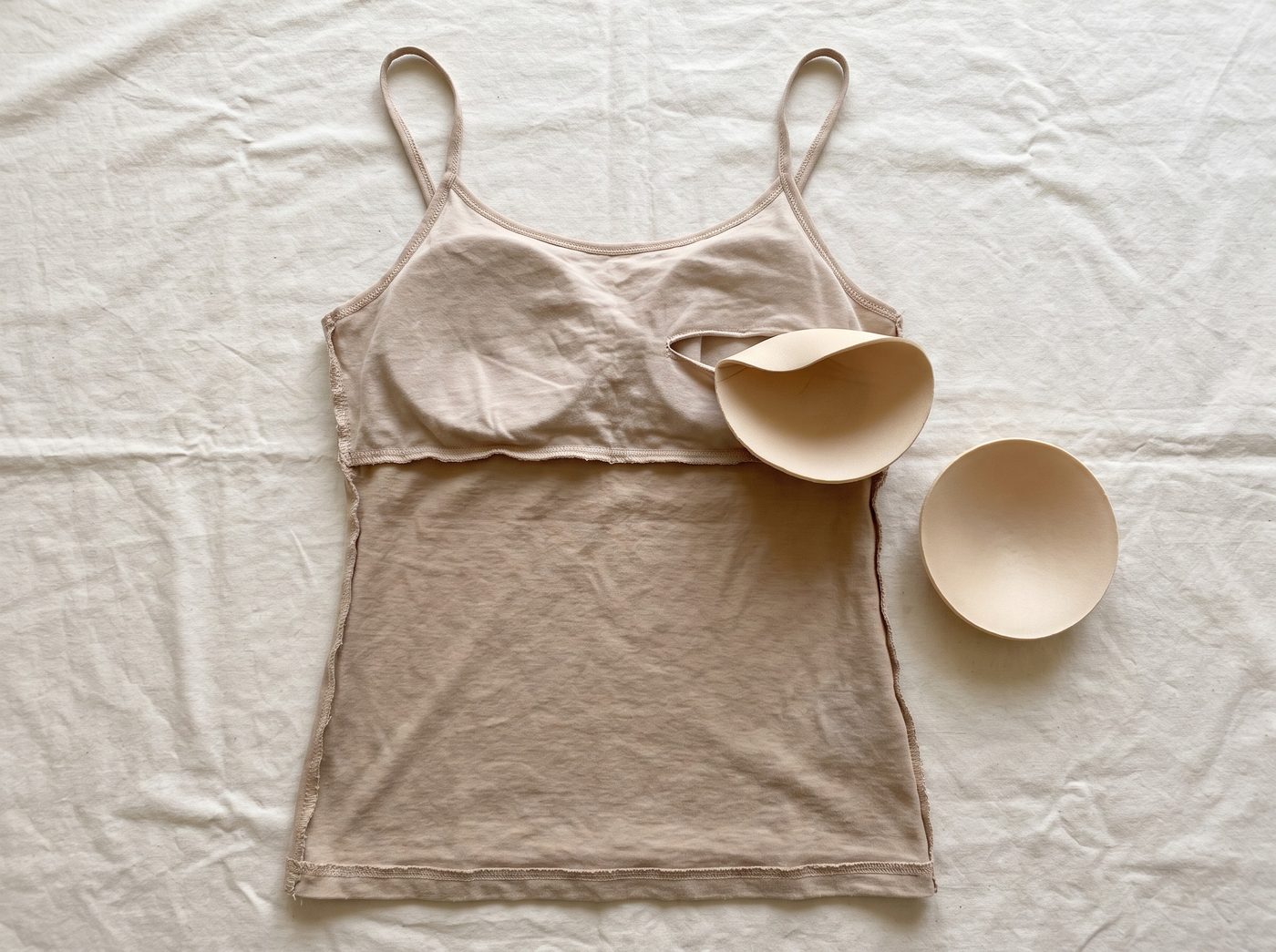 Inside a cheap camisole: a loose foam pad sliding out of a pocket