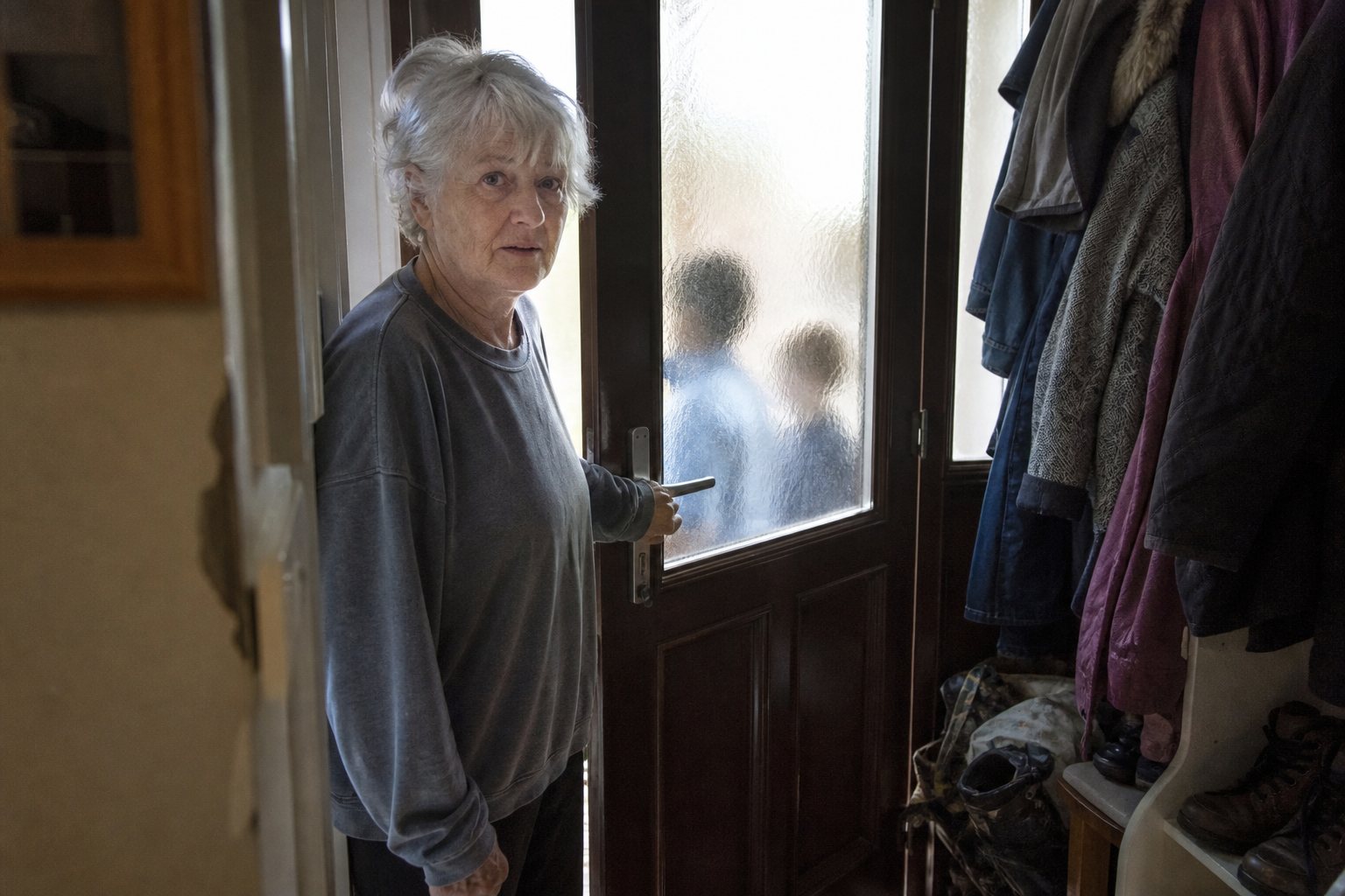 A woman hesitating behind her front door